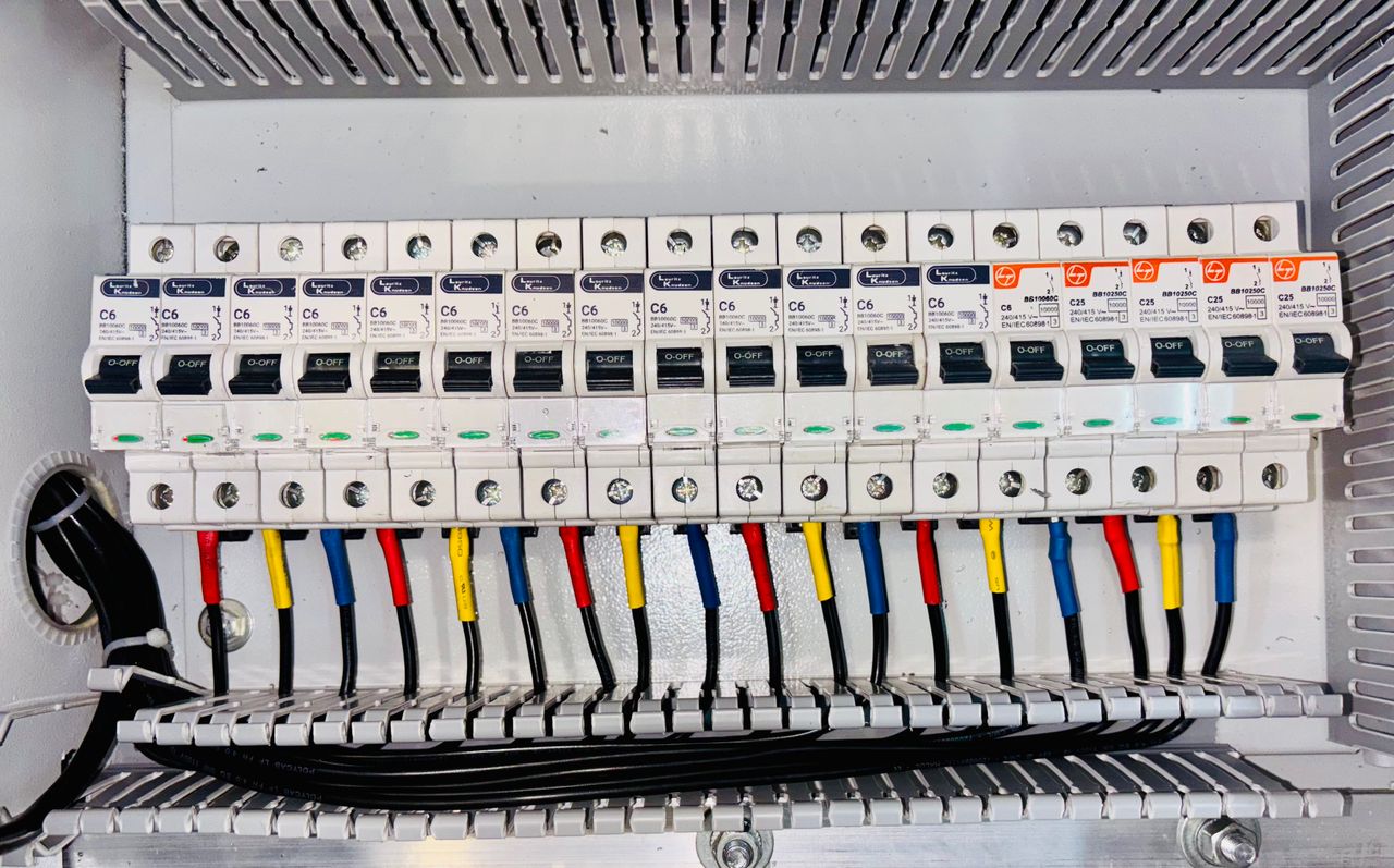 about-img-01 Close-up of an organized circuit breaker panel featuring color-coded electrical wiring.